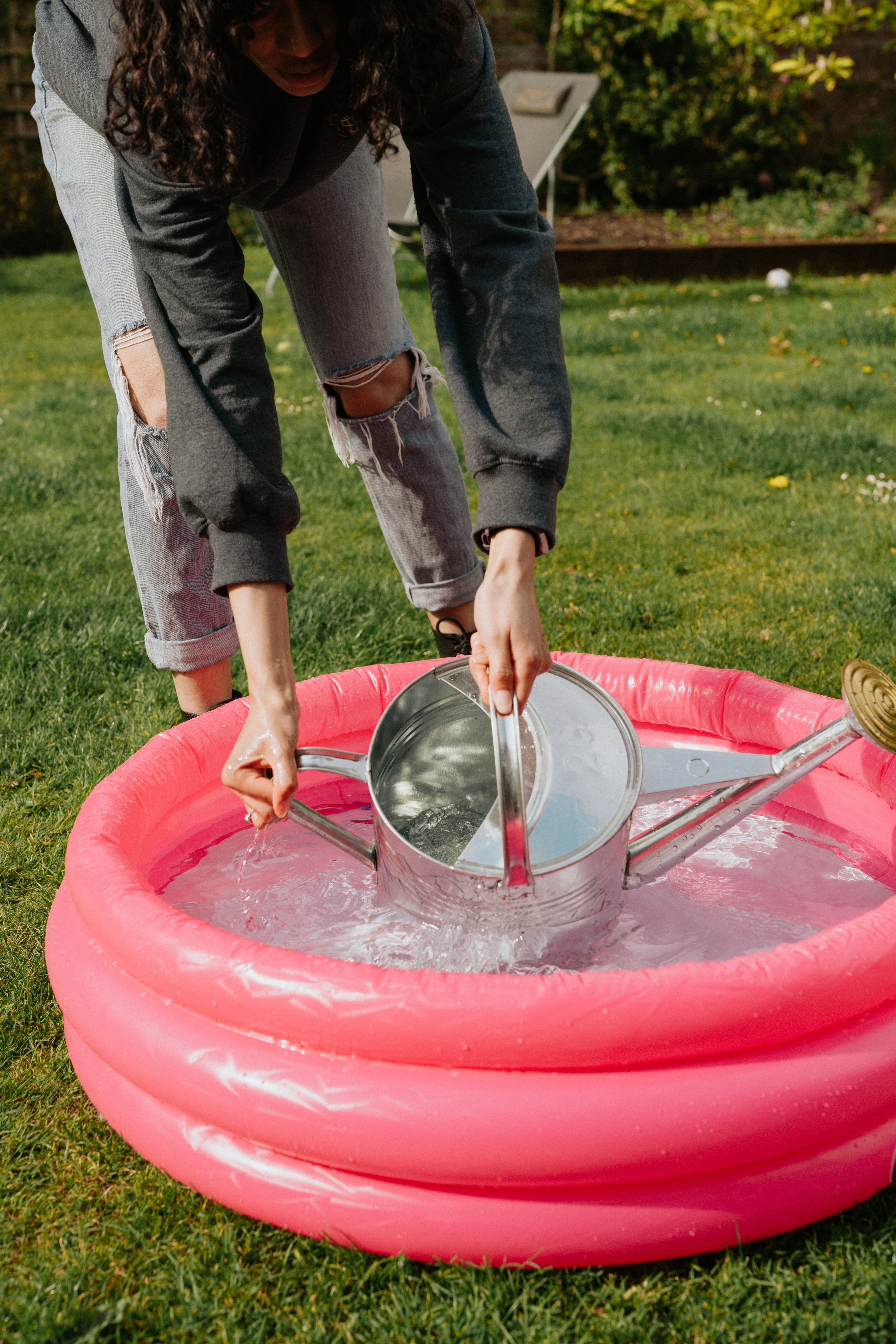Paddling pool and watering can image